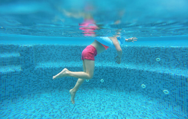 Legs of child girl view from under water. - 写真・画像