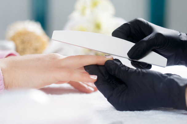 Woman hands receiving a manicure in beauty salon - Фото, изображение