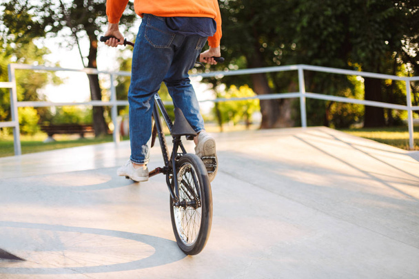 Крупный план молодой парень на велосипеде в современном скейтпарке
 - Фото, изображение