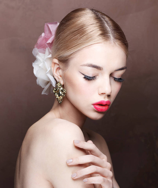 Fashion portrait of young blonde model with pink lips and roses in her hair wearing vintage earrings - Zdjęcie, obraz