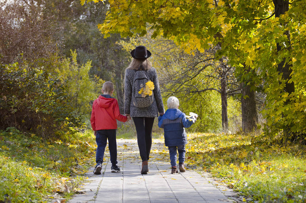 Μητέρα και δύο γιους, το περπάτημα στο δάσος το φθινόπωρο. Πίσω όψη - Φωτογραφία, εικόνα