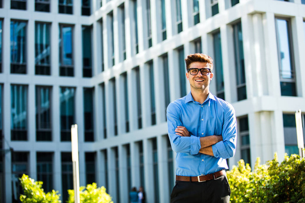 successful antrepreneur standing confident in front of an office bulding in blue shirt - Фото, изображение