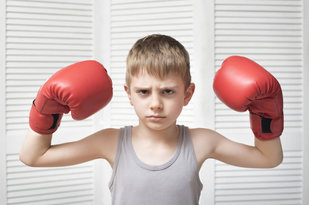 Angry boy in red boxing gloves. - Фото, зображення
