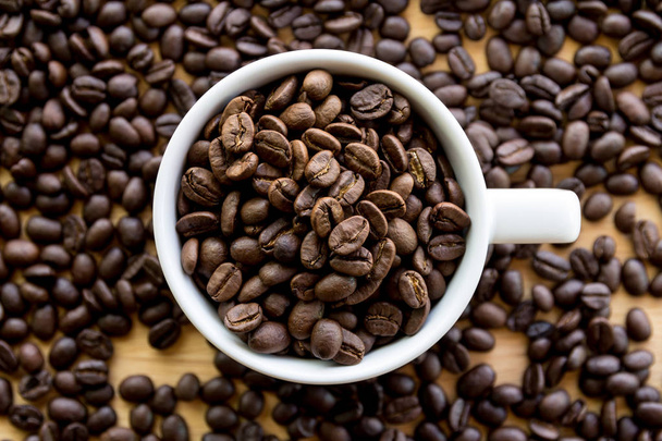 Close up of white coffee cup full of coffee beans background with copy space - Photo, image