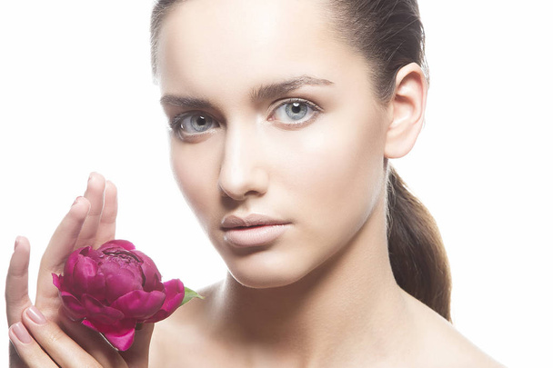 Portrait of young woman with natural makeup and peony flower on white background - Photo, image