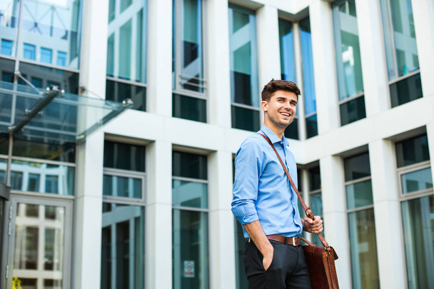 confident and successful antrepreneur, office man or corporate guy, standing with his leather bag and elegant outfit in front of an office building - Photo, Image