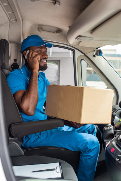 african american delivery man talking by smartphone in van - Foto, Imagen