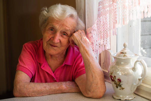 Портрет літньої жінки в її будинку на кухні
.  - Фото, зображення