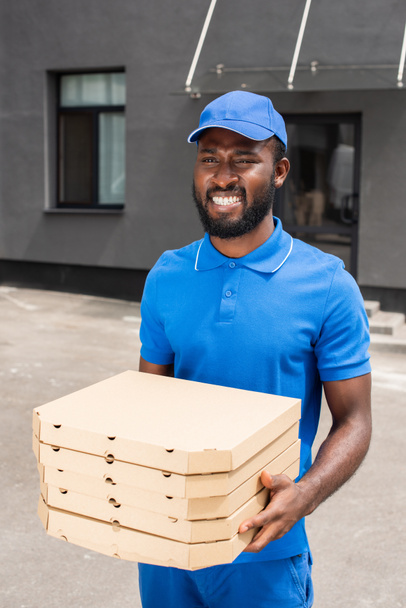 smiling african american delivery man holding pizza boxes - Photo, Image