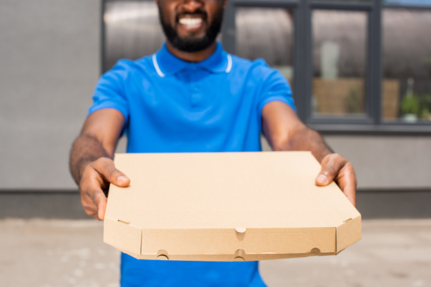 levágott kép mutatja a pizzás doboz afro-amerikai szállítási ember - Fotó, kép