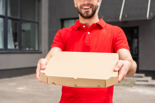 cropped image of delivery man holding box with pizza - Fotografie, Obrázek