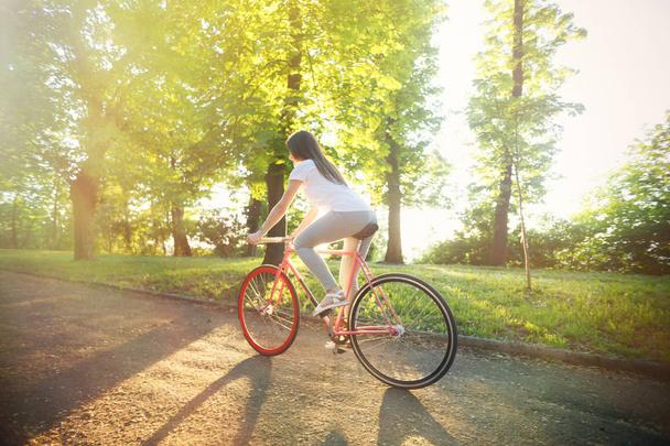 Kız binmek bisiklet günbatımı üzerinde - Fotoğraf, Görsel