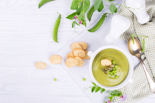 Green pea soup puree with croutons in black bowl.  On white background. flat lay.. Copy space - Photo, Image