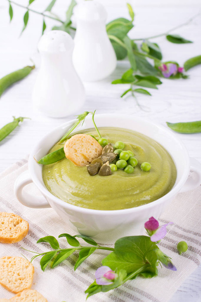 Léger été délicieux pois verts soupe à la crème servie avec des graines de citrouille, croûtons sur fond blanc
. - Photo, image