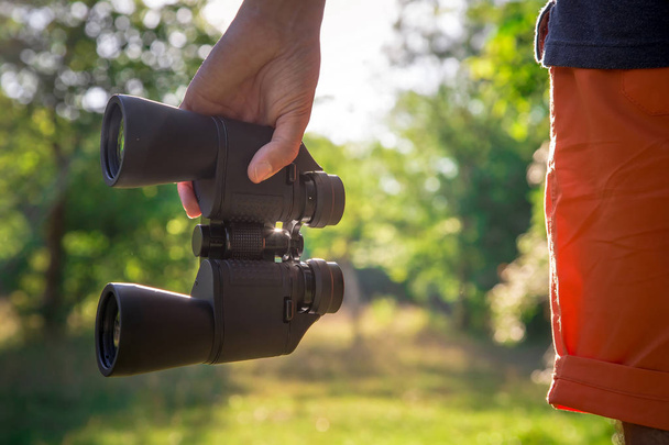 Αρσενικό πεζοπόρος που ψάχνει μέσα από κιάλια στο δάσος - Φωτογραφία, εικόνα