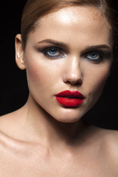 close up portrait of beautiful female model with red lips and wavy hair on black background - Valokuva, kuva