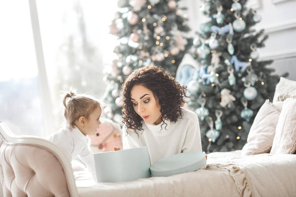 Krásná mladá matka s dcerou roztomilá malá slaví vánoční svátky - Fotografie, Obrázek
