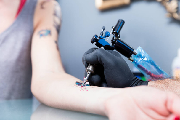 Közeli kép: a kéz egy tetováló művész egy színes pillangó árnyékolás - Fotó, kép