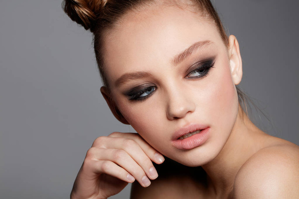 Studio portrait of beautiful teen model with smoky eyes make up. Fresh skin. Perfect style - Zdjęcie, obraz