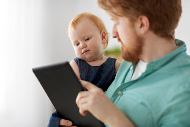 father and baby daughter with tablet pc at home - Foto, imagen