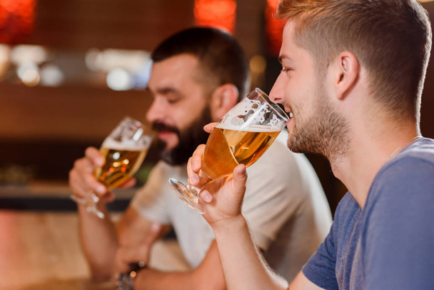 Two bearded men drinking beer in cafe. - Foto, imagen