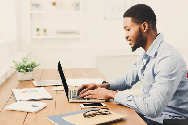 Jonge zwarte zakenman werken met laptop - Foto, afbeelding