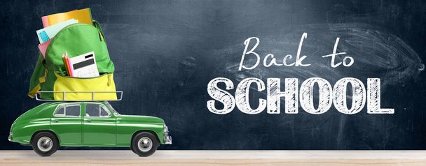 Back to school sale background. Car delivering backpack full of accessories against blackboard - Photo, image
