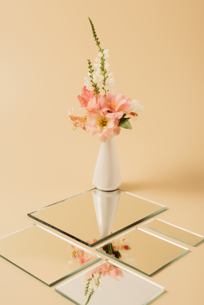 Lelie bloemen in vaas weerspiegelen in spiegels op beige tafel  - Foto, afbeelding