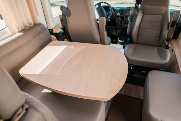 RV Camper Van Dinning Area with Wooden Table and Seats. Traveling in Style. - Photo, Image