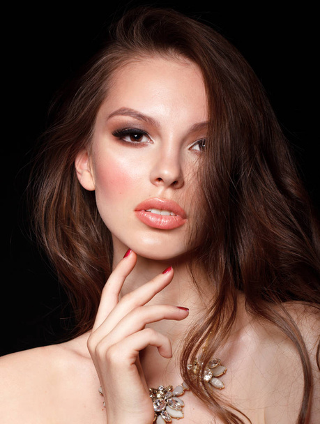 Beautiful young female model with necklace touching her face with hand - Zdjęcie, obraz