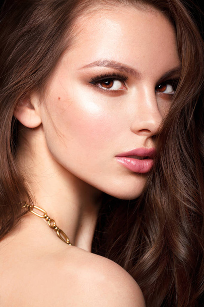 Beautiful young female model with golden necklace - Fotó, kép