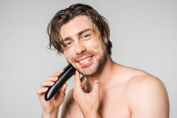 portrait d'un bel homme souriant avec tondeuse électrique barbe à raser isolée sur gris
 - Photo, image