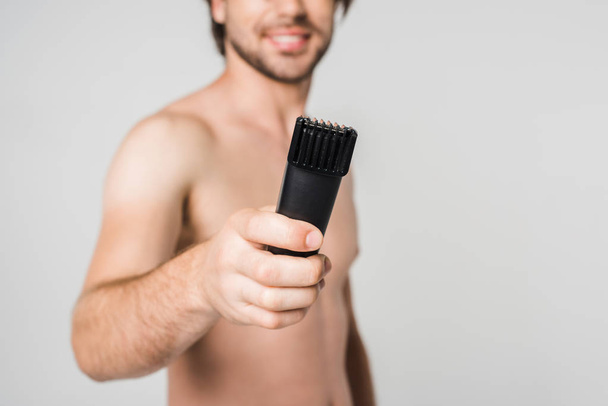 partial view of shirtless man with electric clipper isolated on grey - Фото, зображення