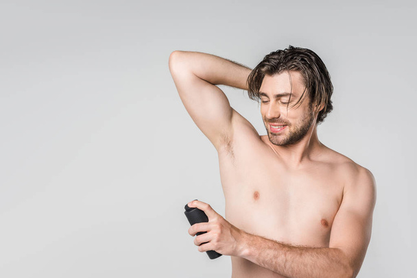 portrait of handsome man with male deodorant isolated on grey - Foto, Imagem