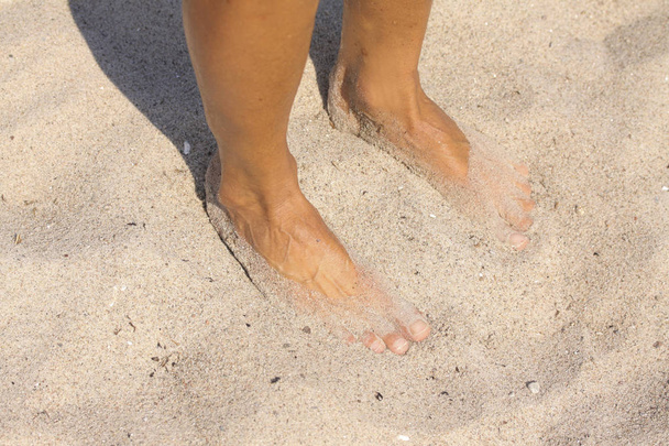 Pies de una mujer en arena fina de playa blanca
 - Foto, Imagen