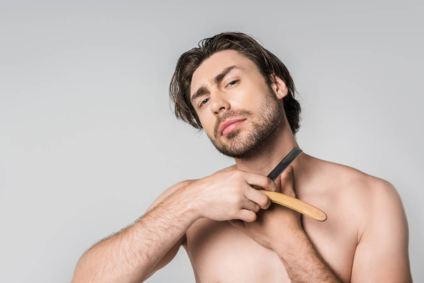 portrait of shirtless man with straight razor in hands isolated on grey - Zdjęcie, obraz
