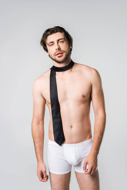 portrait of handsome man in white underwear with black tie on grey backdrop - Photo, Image