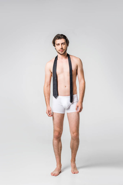 handsome man in white underwear with black tie on grey backdrop - Photo, Image