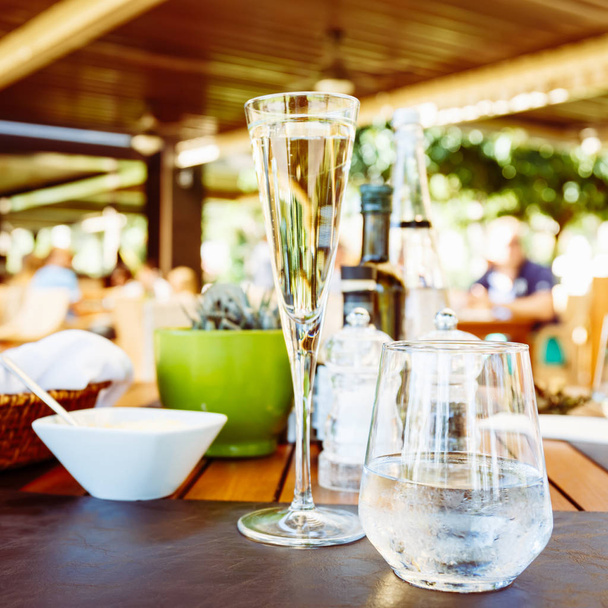 Vino y agua en la mesa. Terraza exterior del restaurante italiano. Concepto de comida auténtica de verano. Cuadrado
 - Foto, imagen