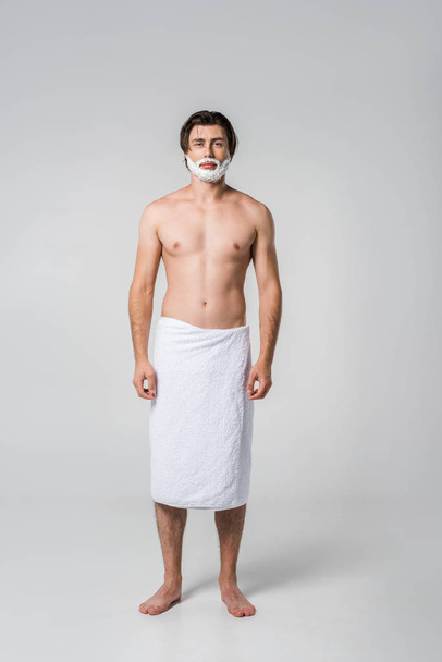shirtless man in towel with shaving foam on face isolated on grey - Фото, изображение