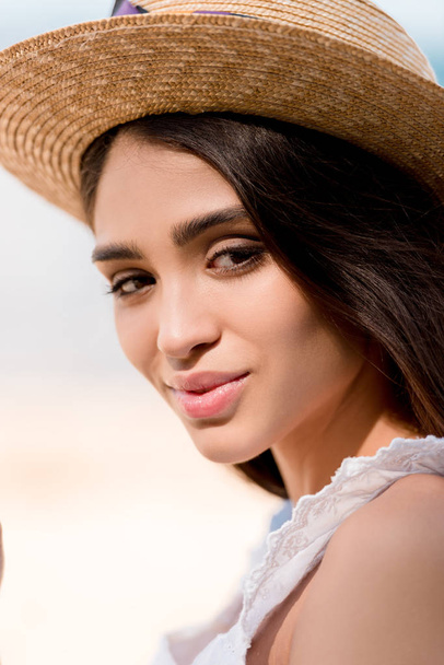 attractive brunette girl posing in straw hat and looking at camera - Φωτογραφία, εικόνα