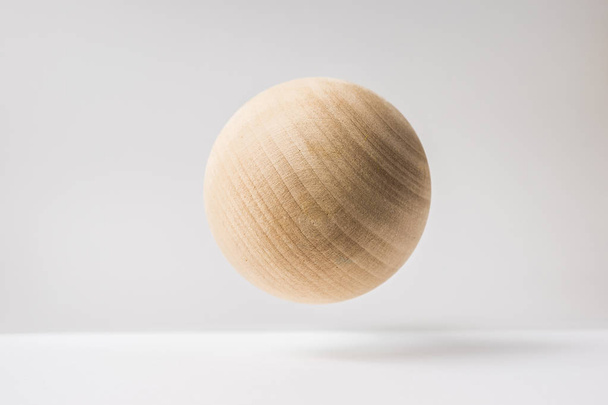 Design concept - abstract real wooden sphere with surreal layout on white surface background and it's not 3D render - Photo, Image