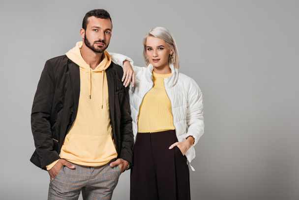 couple dressed in stylish autumn clothes posing isolated on grey background - Foto, immagini