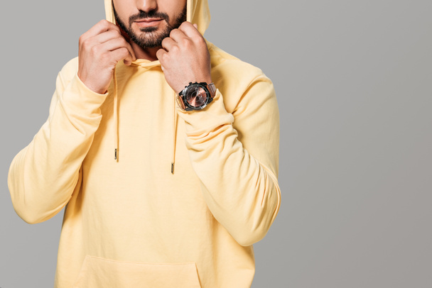 cropped image of bearded stylish man in yellow hoodie isolated on grey background  - Foto, Bild