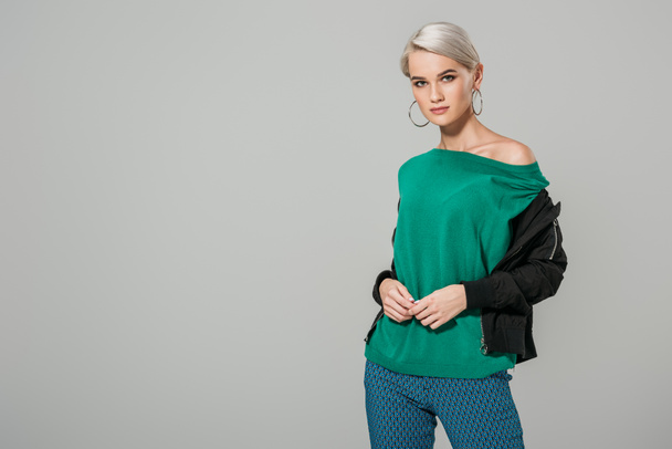 attractive young woman in green sweater posing isolated on grey background - Photo, Image