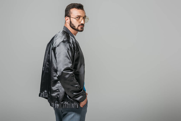 confident handsome man in stylish black bomber isolated on grey background - Foto, imagen