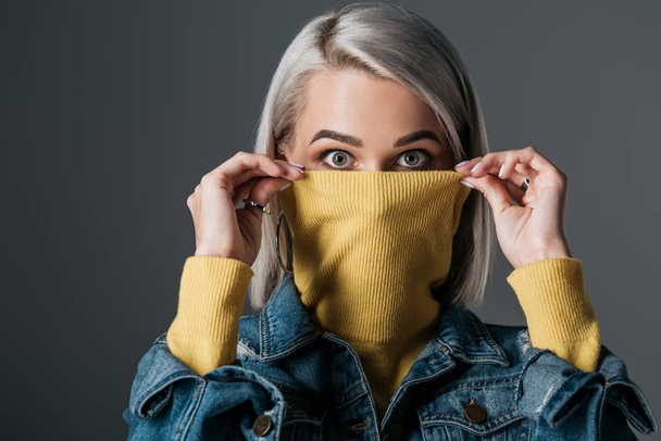 femme choquée en col roulé jaune et veste en jean, isolée sur gris
 - Photo, image