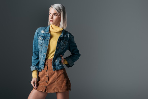 attractive woman posing in yellow turtleneck, trendy corduroy skirt and jeans jacket, isolated on grey - Foto, immagini