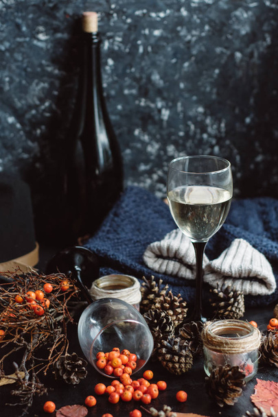  wine in glasses ,red berries,bumps and autumn branches on dark table. Autumn or Winter concept. - Foto, imagen