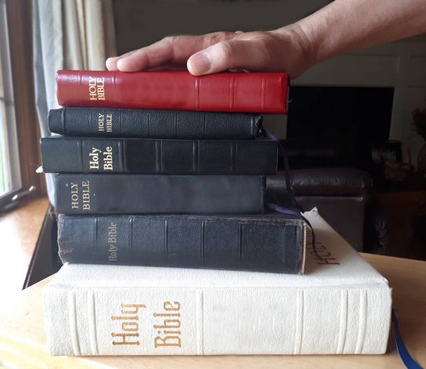 Een hand bovenop een stapel van Bijbels is klaar om te zweren van de waarheid  - Foto, afbeelding
